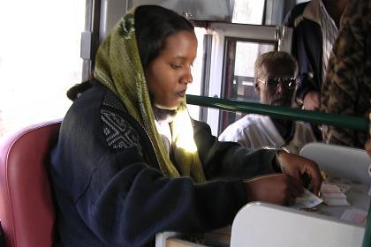 Casher selling tickets in the back of an Asmara public bus